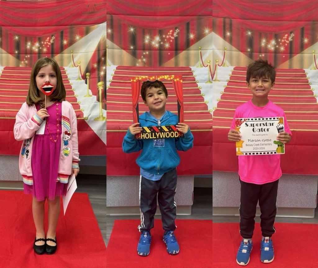 S.T.A.R. Gator Students pose in a room with a red carpet backdrop.