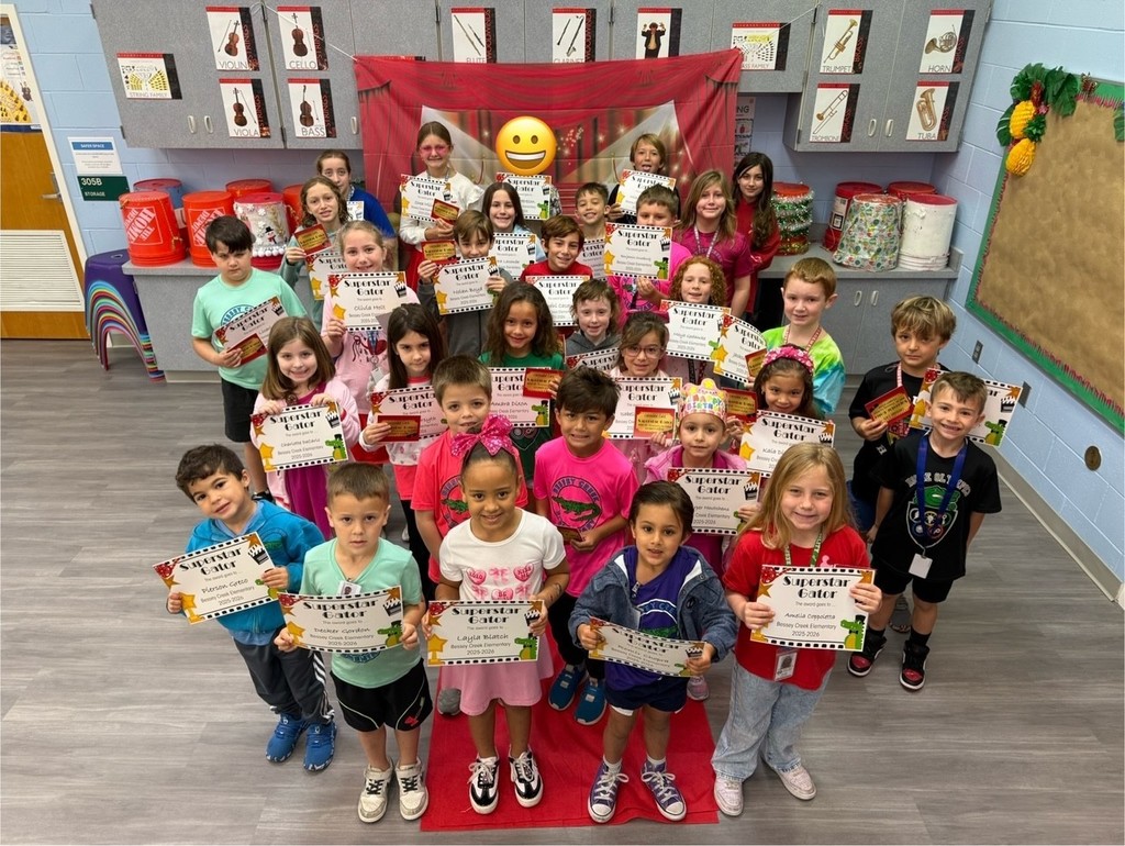 S.T.A.R. Gator Students pose in a room with a red carpet backdrop.