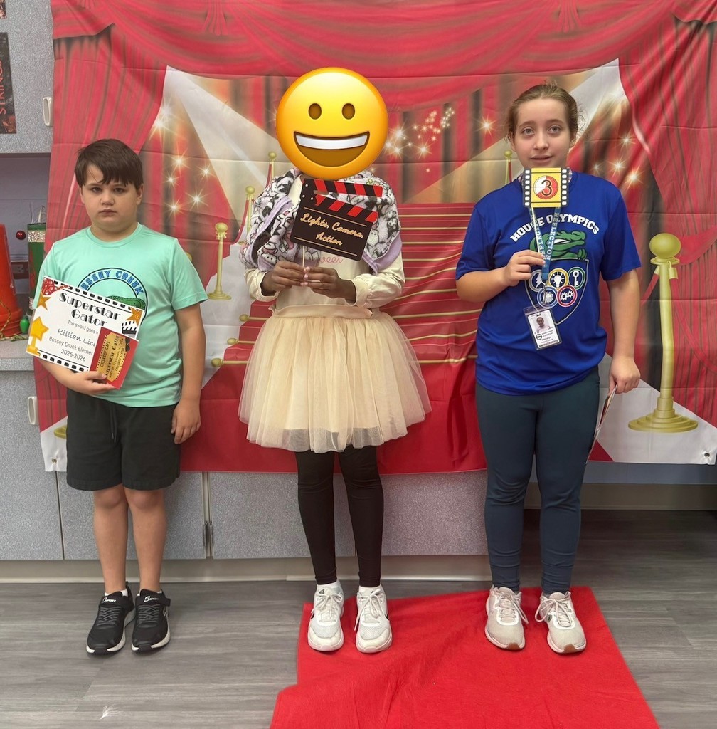 S.T.A.R. Gator Students pose in a room with a red carpet backdrop.