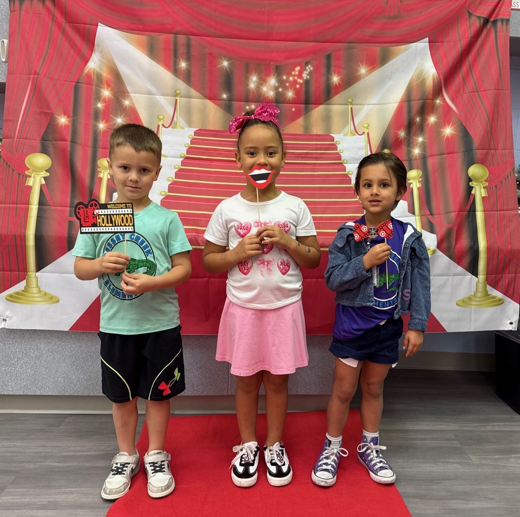 S.T.A.R. Gator Students pose in a room with a red carpet backdrop.