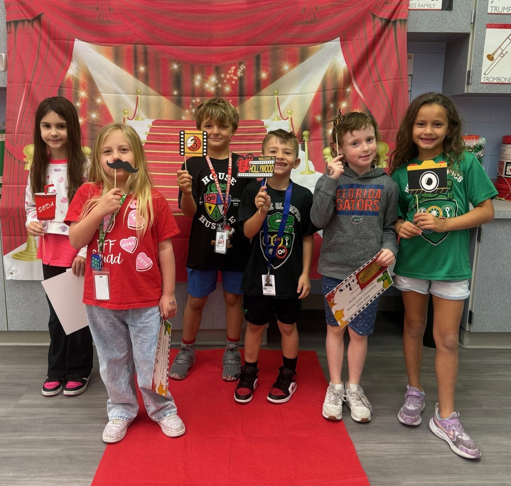 S.T.A.R. Gator Students pose in a room with a red carpet backdrop.