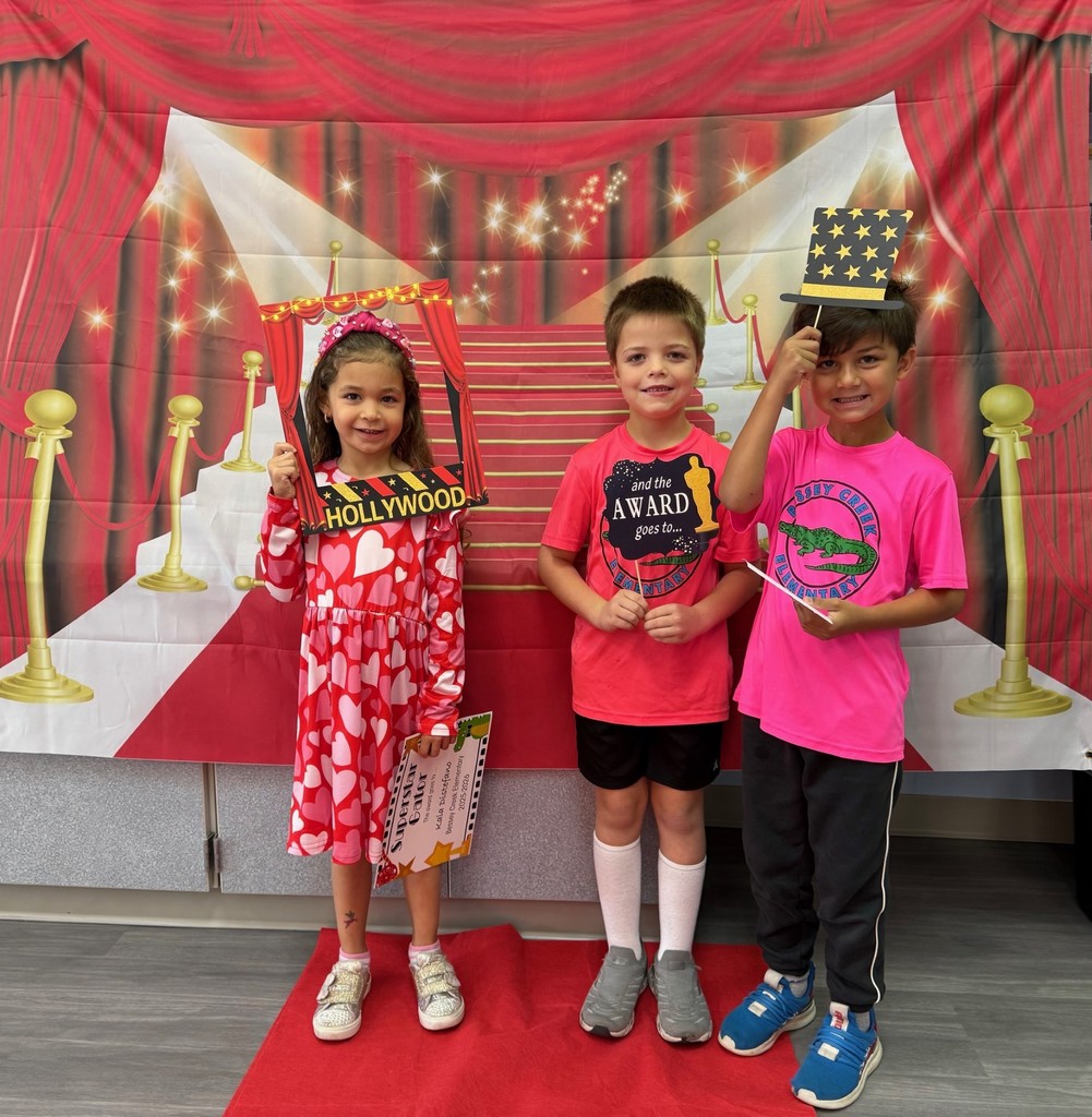 S.T.A.R. Gator Students pose in a room with a red carpet backdrop.