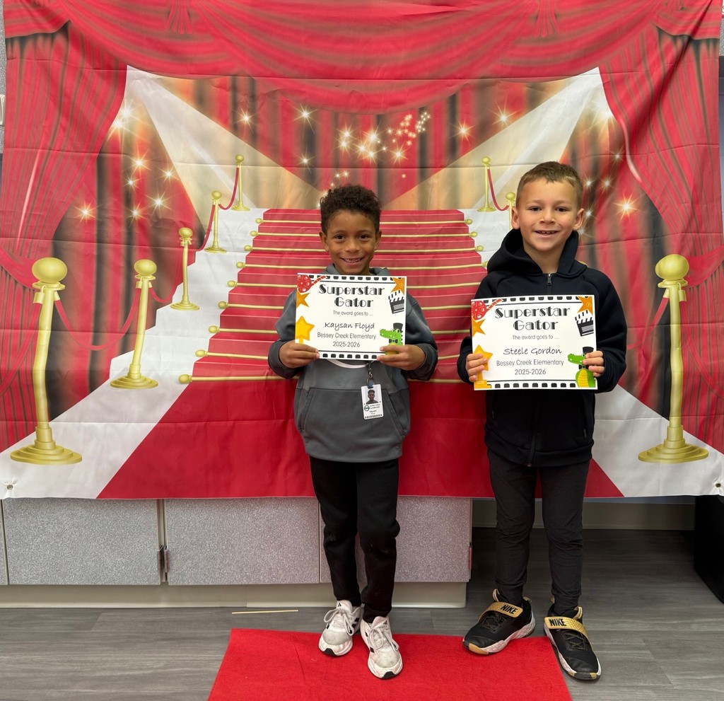 S.T.A.R. Gator Students pose in a room with a red carpet backdrop.