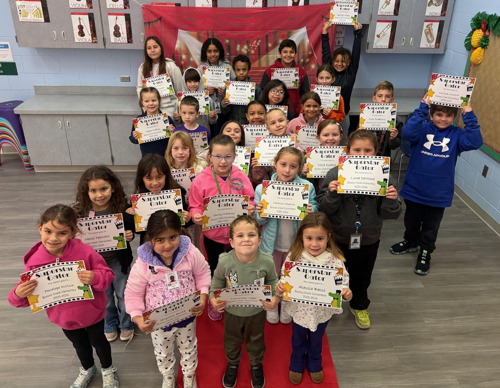 S.T.A.R. Gator Students pose in a room with a red carpet backdrop.