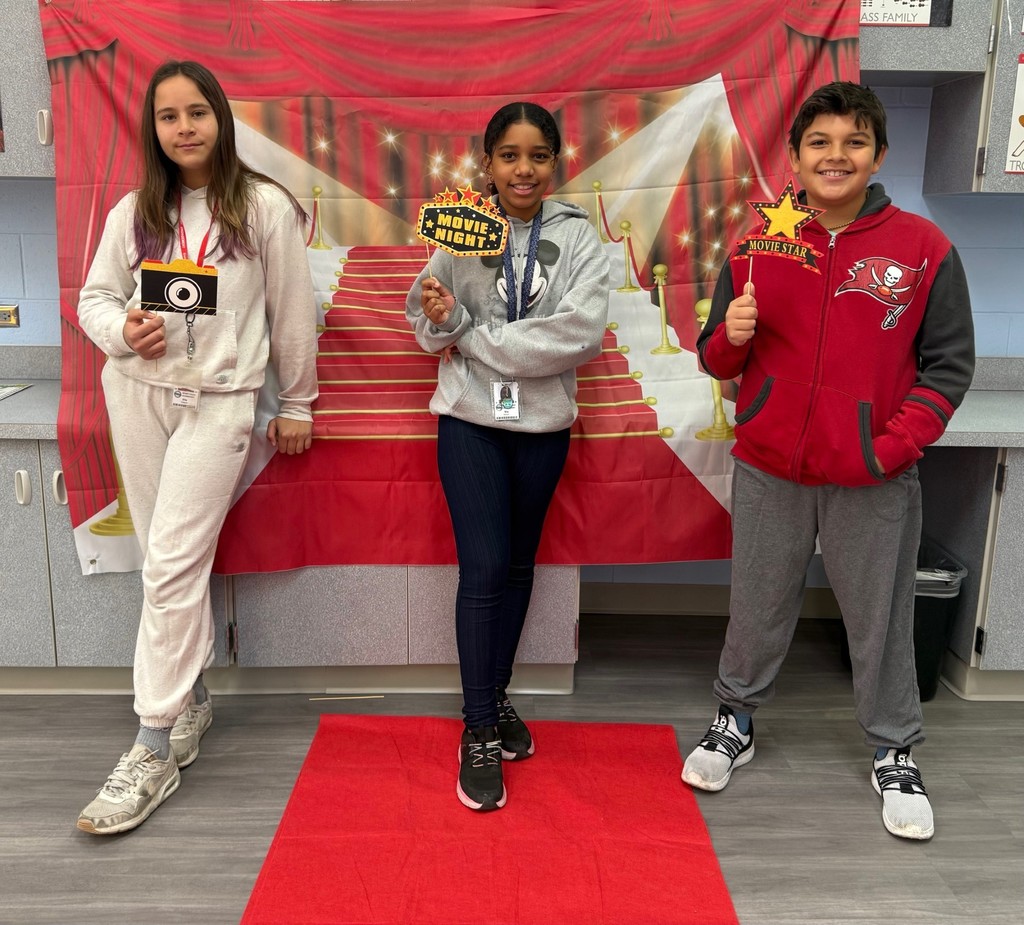 S.T.A.R. Gator Students pose in a room with a red carpet backdrop.