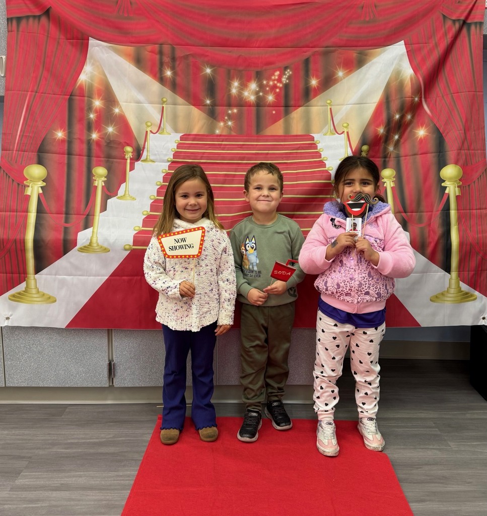 S.T.A.R. Gator Students pose in a room with a red carpet backdrop.