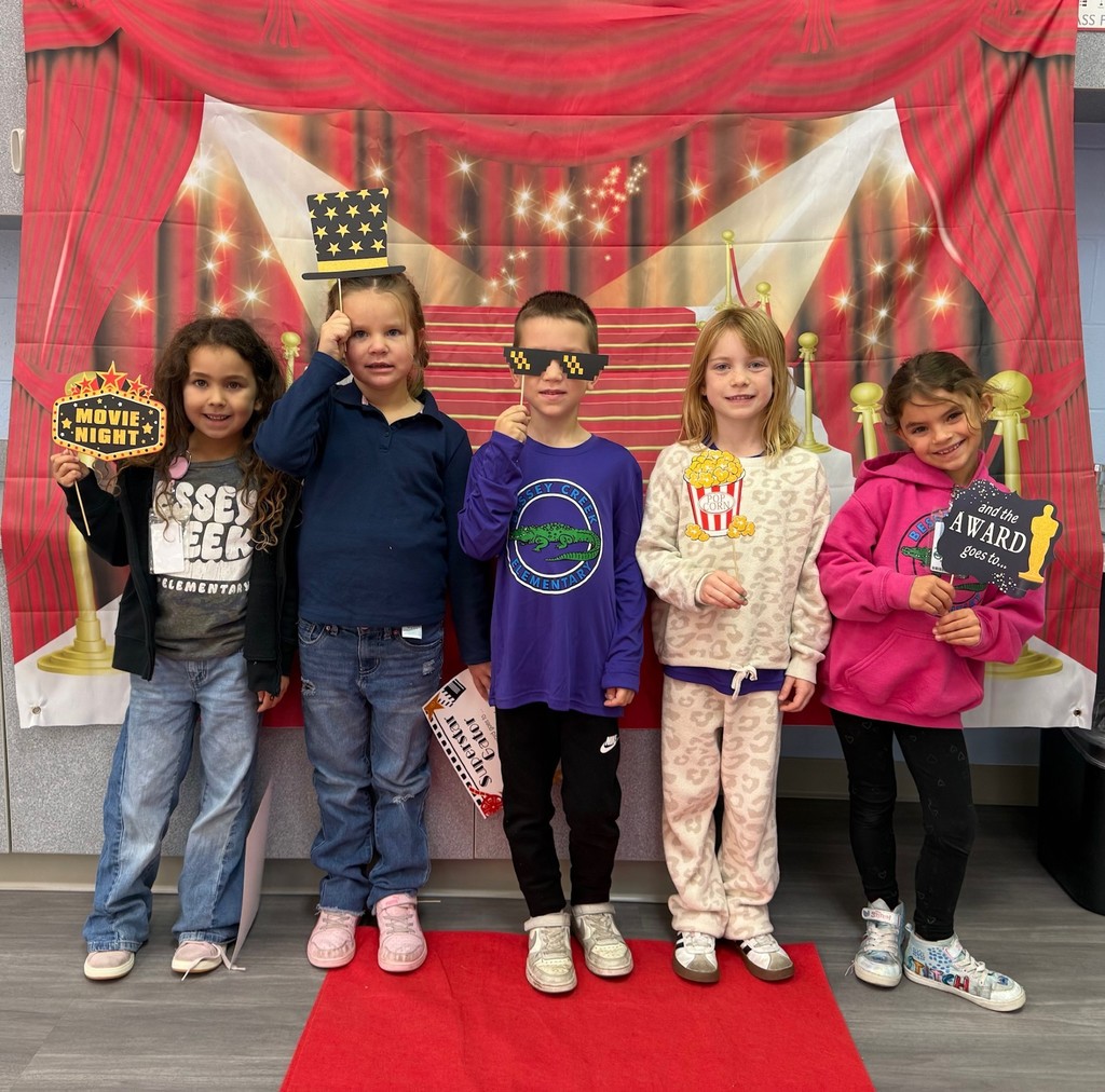 S.T.A.R. Gator Students pose in a room with a red carpet backdrop.