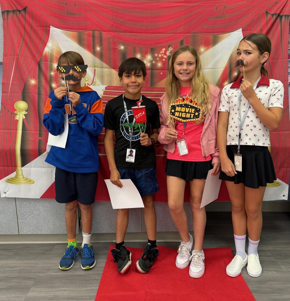 S.T.A.R. Gator Students pose in a room with a red carpet backdrop.