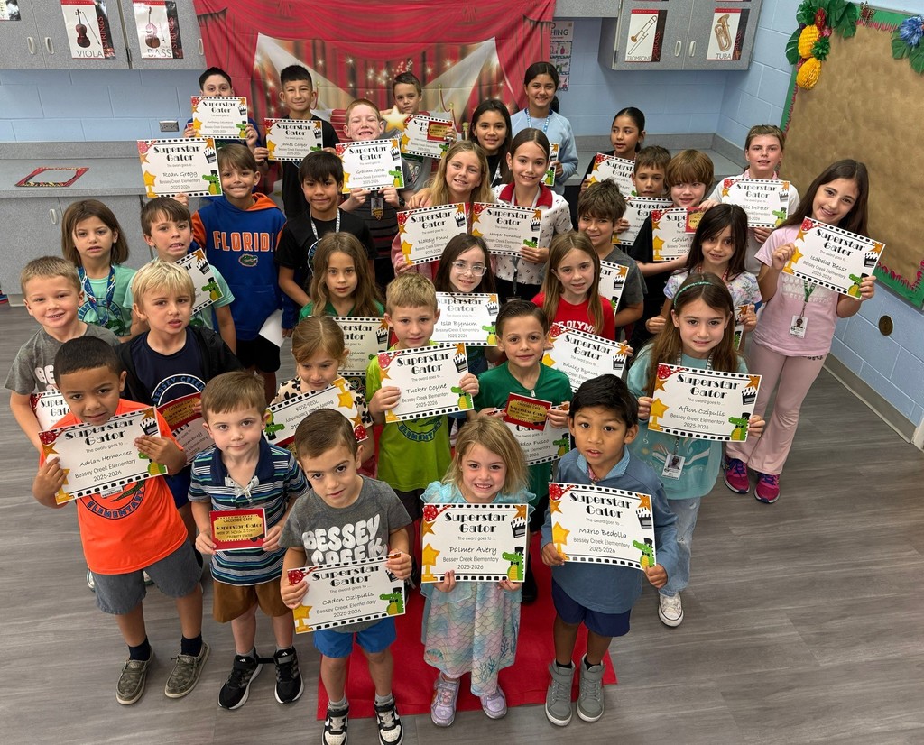 S.T.A.R. Gator Students pose in a room with a red carpet backdrop.