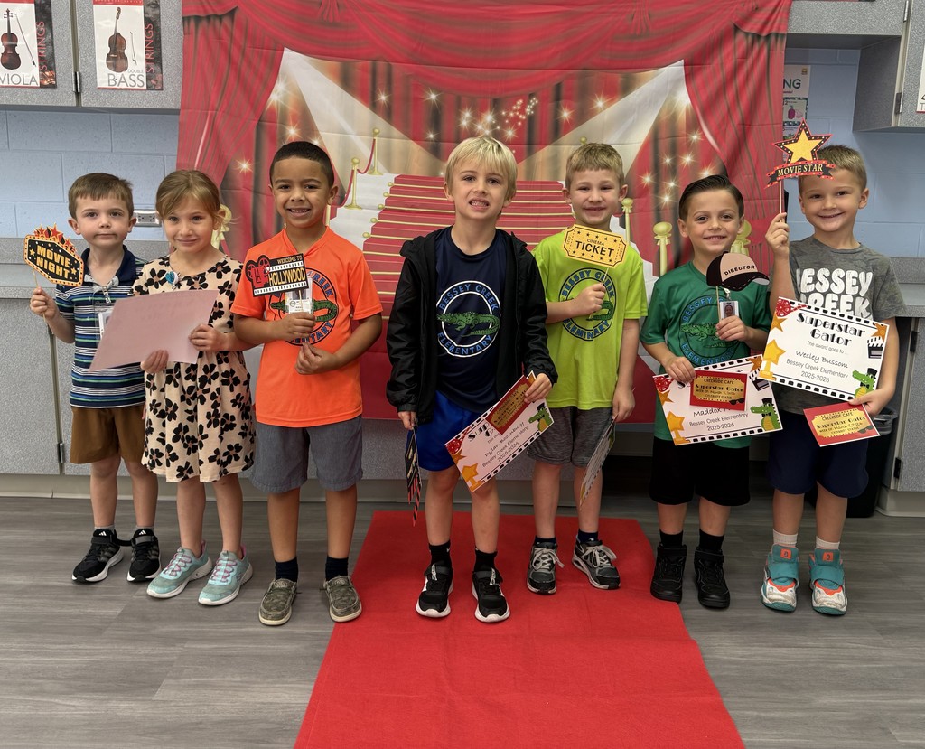 S.T.A.R. Gator Students pose in a room with a red carpet backdrop.