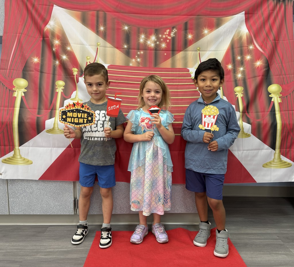 S.T.A.R. Gator Students pose in a room with a red carpet backdrop.