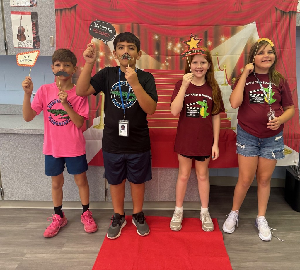 S.T.A.R. Gator Students pose in a room with a red carpet backdrop.