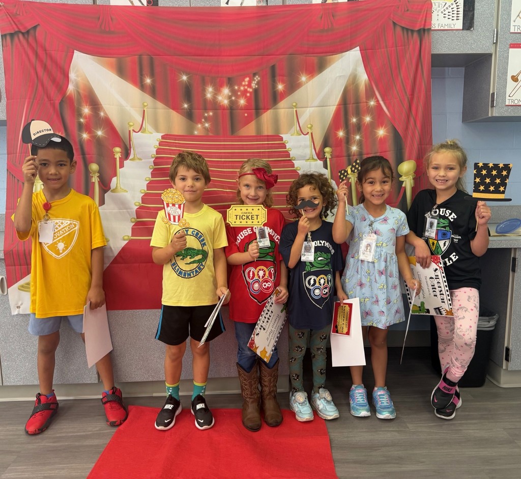 S.T.A.R. Gator Students pose in a room with a red carpet backdrop.