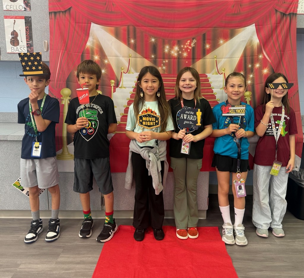 S.T.A.R. Gator Students pose in a room with a red carpet backdrop.