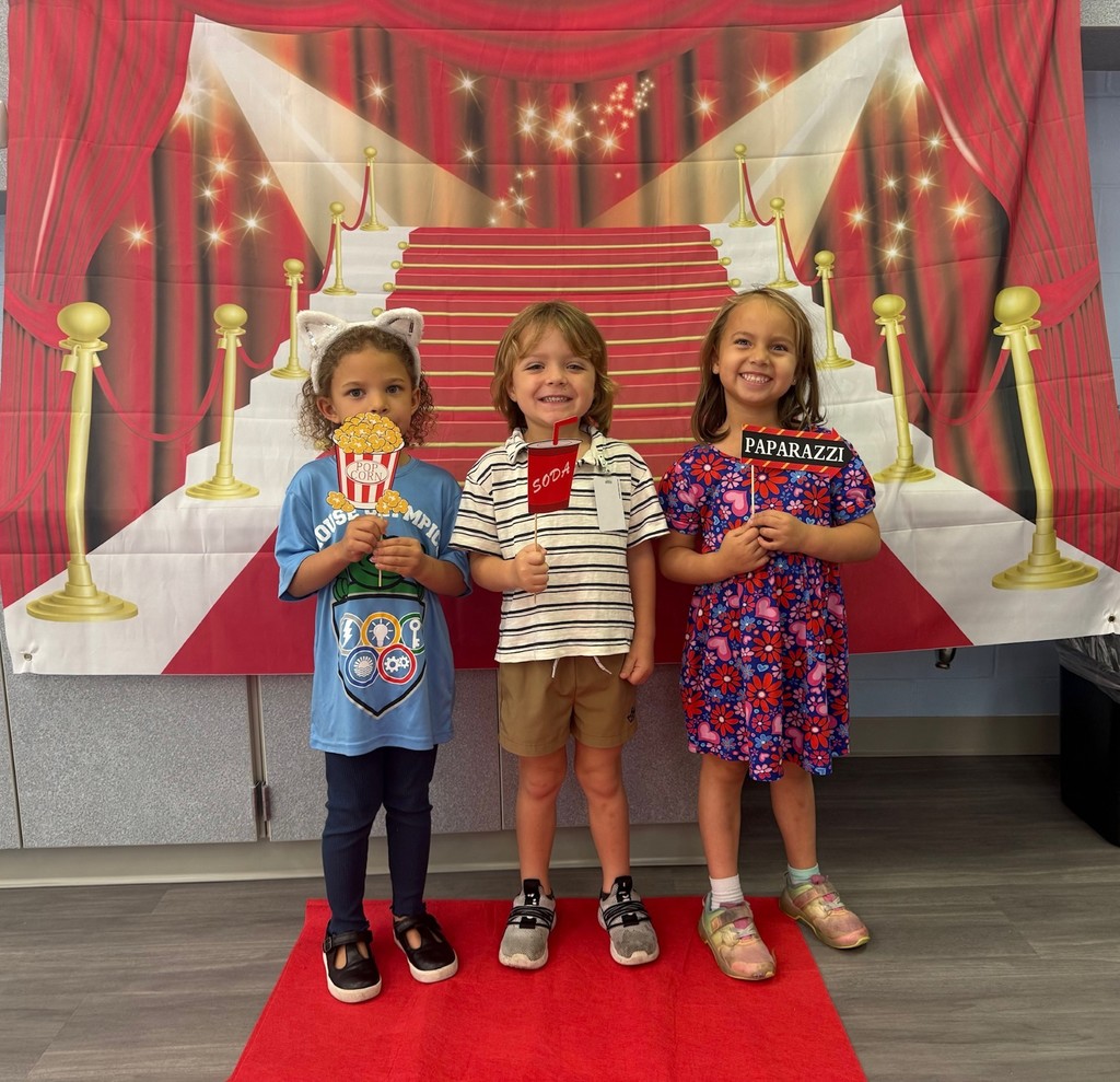S.T.A.R. Gator Students pose in a room with a red carpet backdrop.