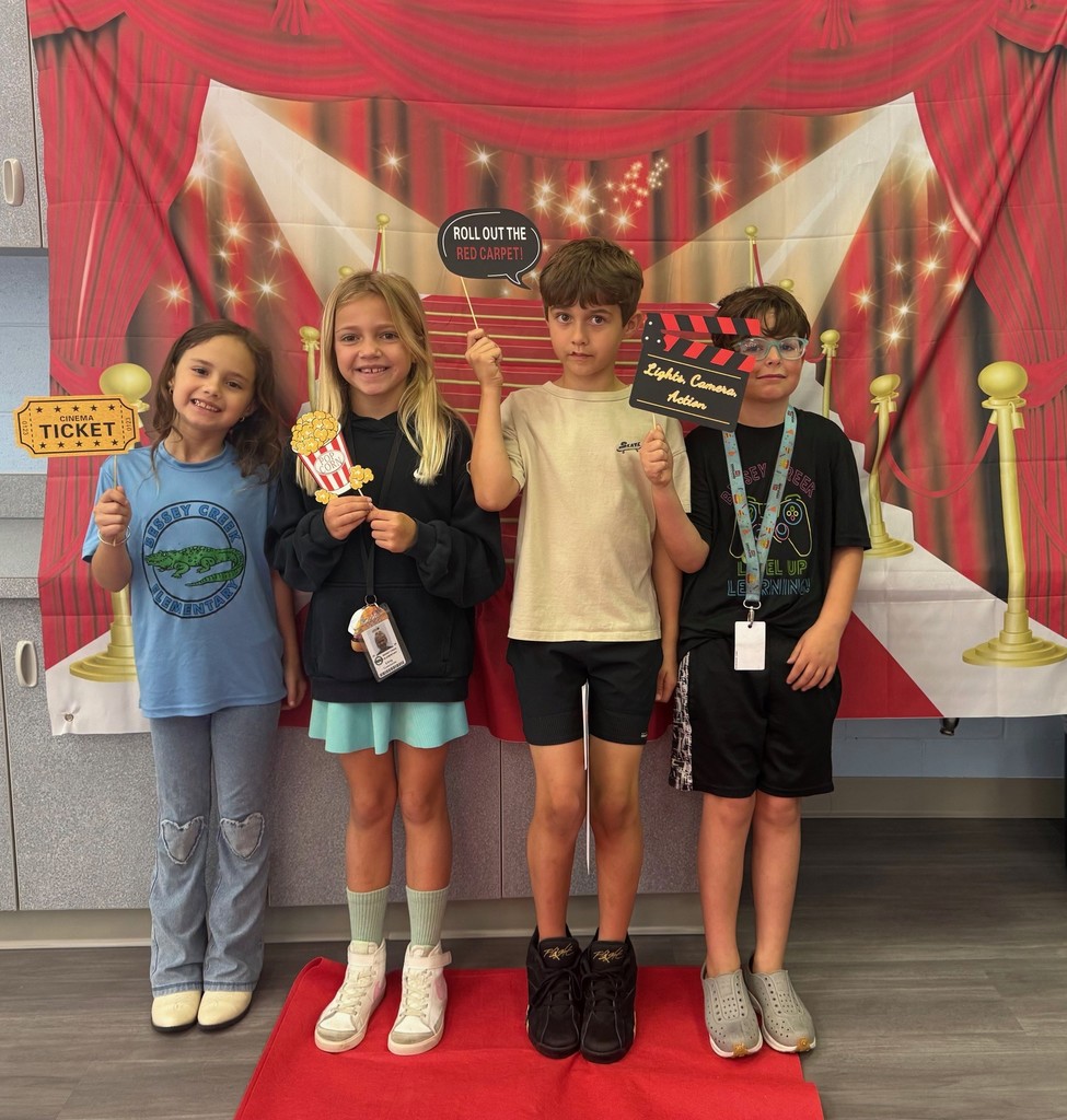 S.T.A.R. Gator Students pose in a room with a red carpet backdrop.