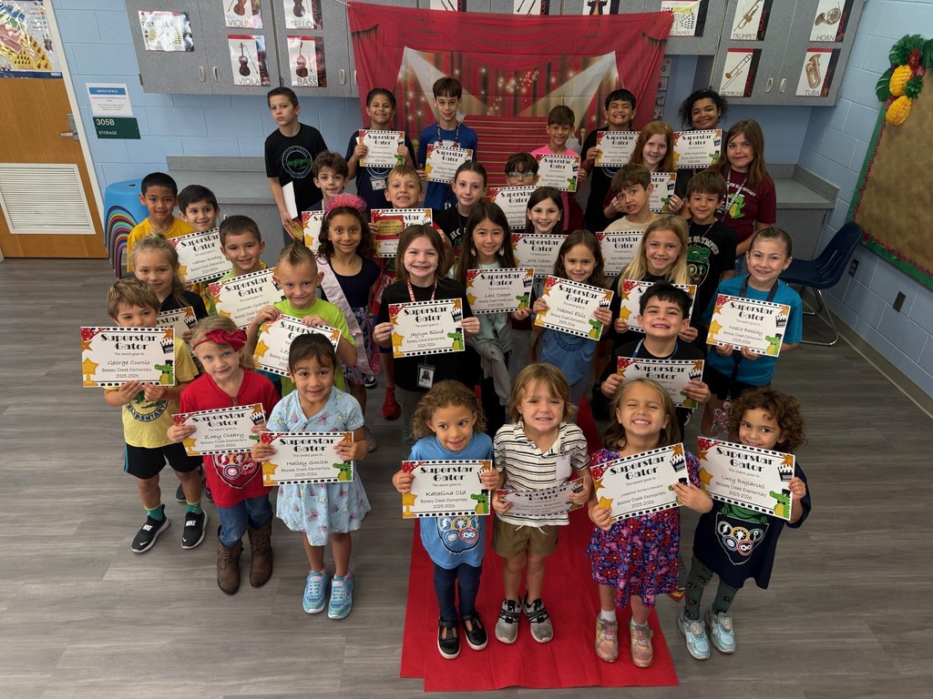 S.T.A.R. Gator Students pose in a room with a red carpet backdrop.