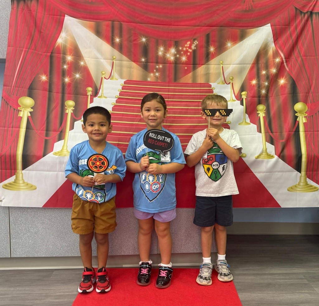 S.T.A.R. Gator Students pose in a room with a red carpet backdrop.