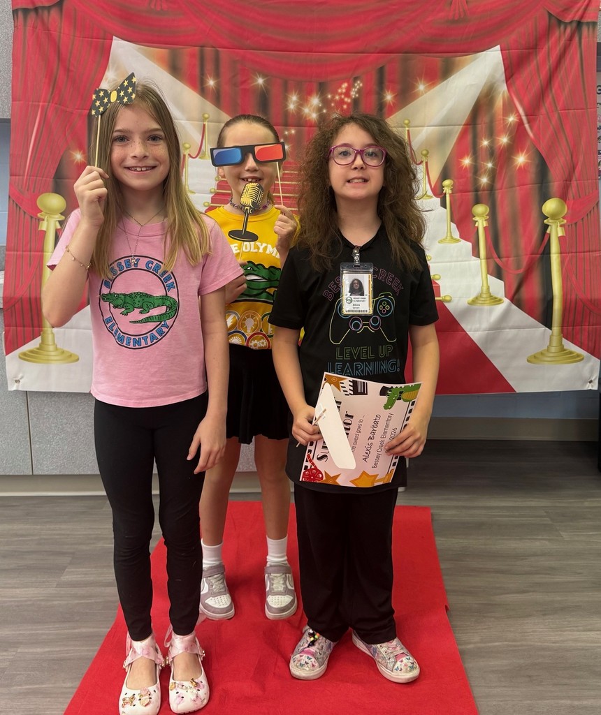 S.T.A.R. Gator Students pose in a room with a red carpet backdrop.