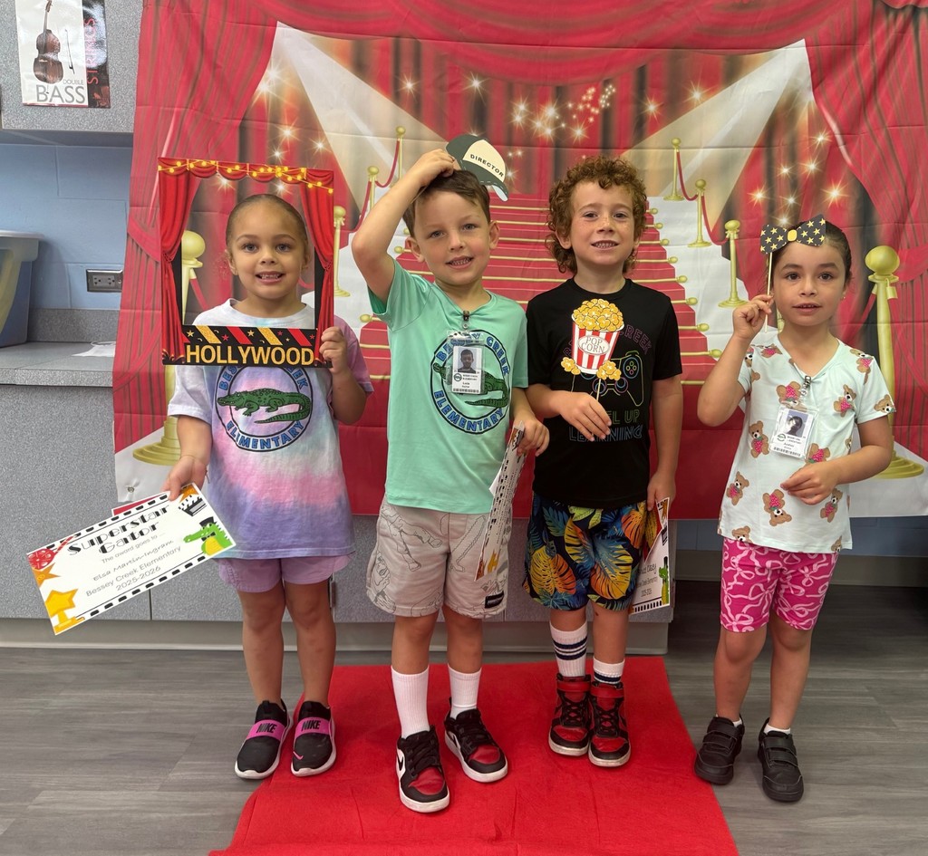 S.T.A.R. Gator Students pose in a room with a red carpet backdrop.