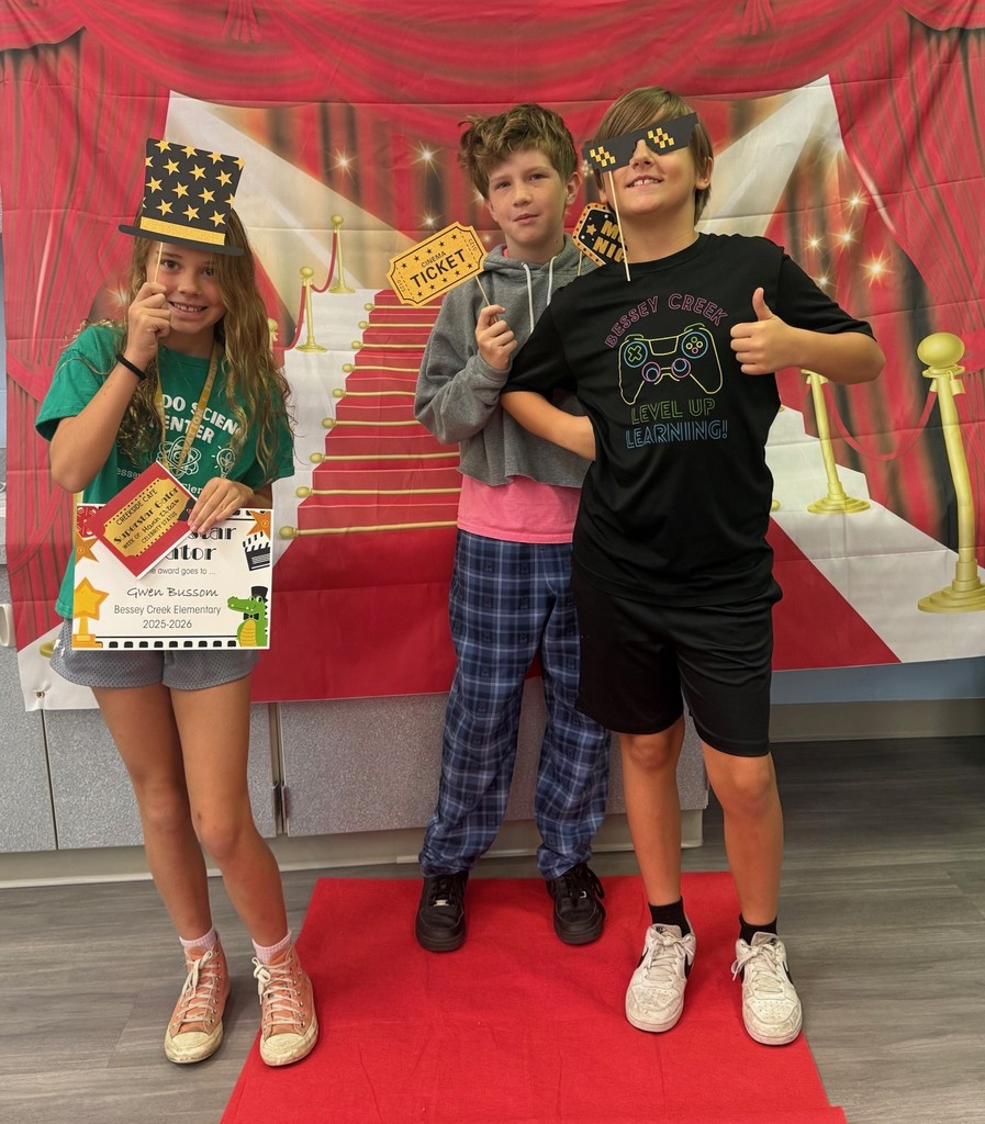 S.T.A.R. Gator Students pose in a room with a red carpet backdrop.