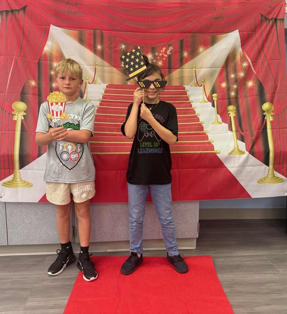 S.T.A.R. Gator Students pose in a room with a red carpet backdrop.