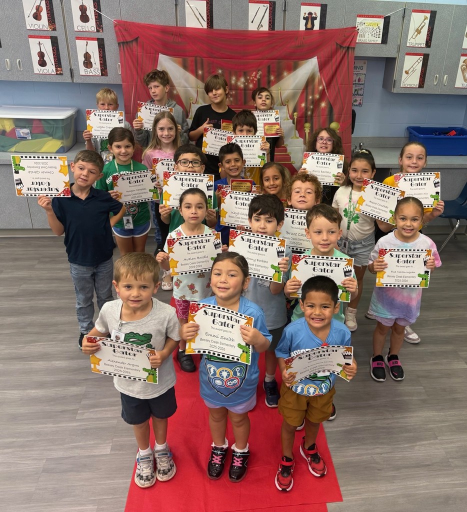 S.T.A.R. Gator Students pose in a room with a red carpet backdrop.