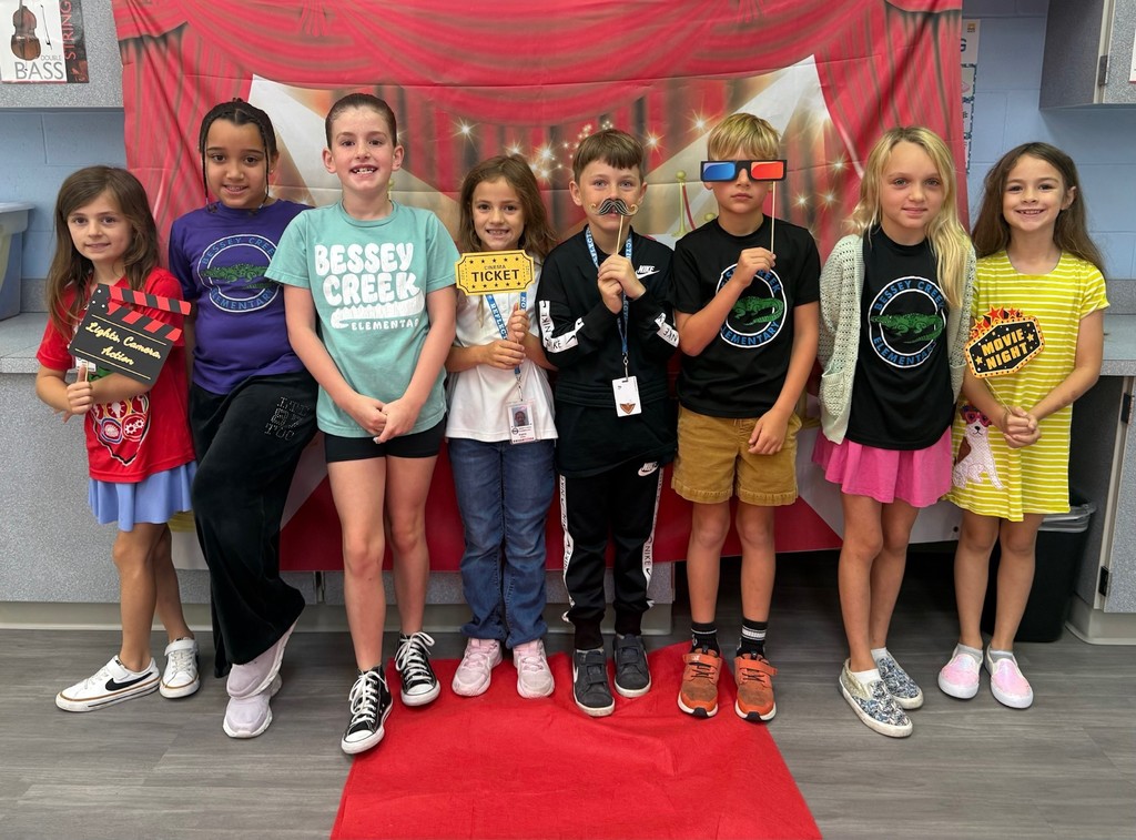 S.T.A.R. Gator Students pose in a room with a red carpet backdrop.