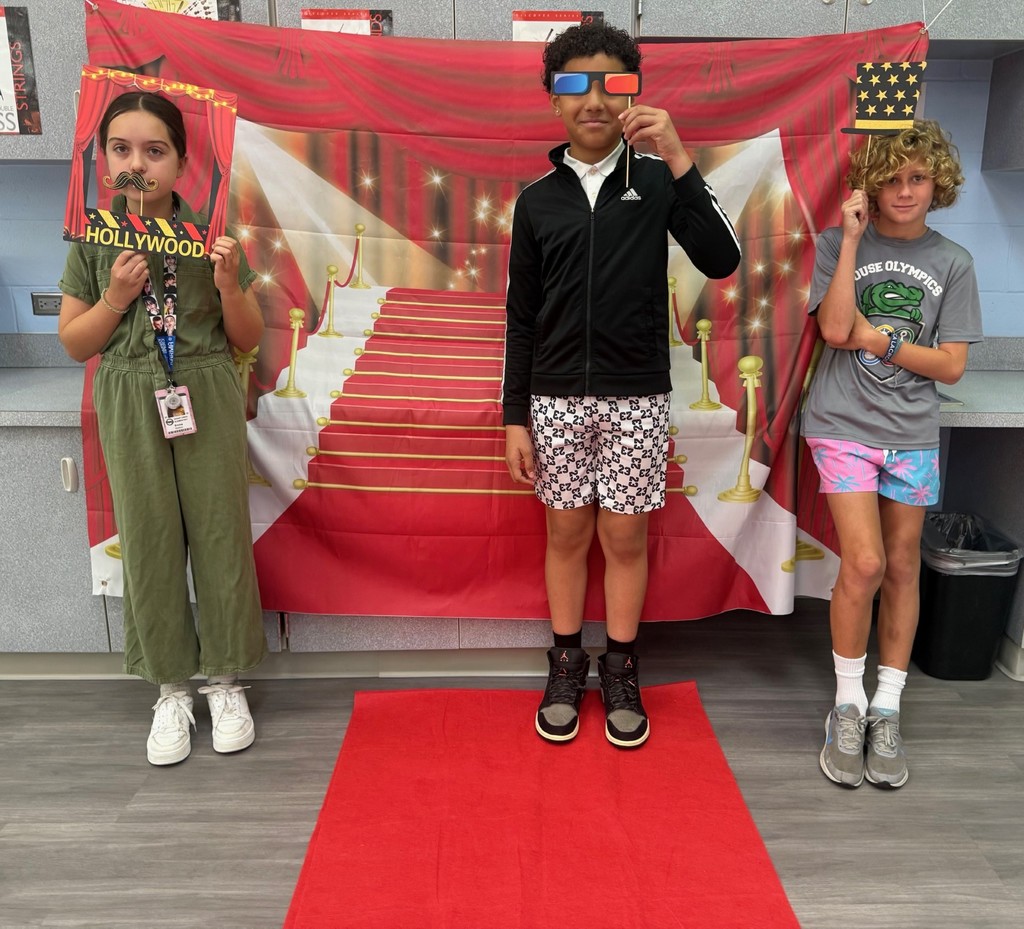 S.T.A.R. Gator Students pose in a room with a red carpet backdrop.