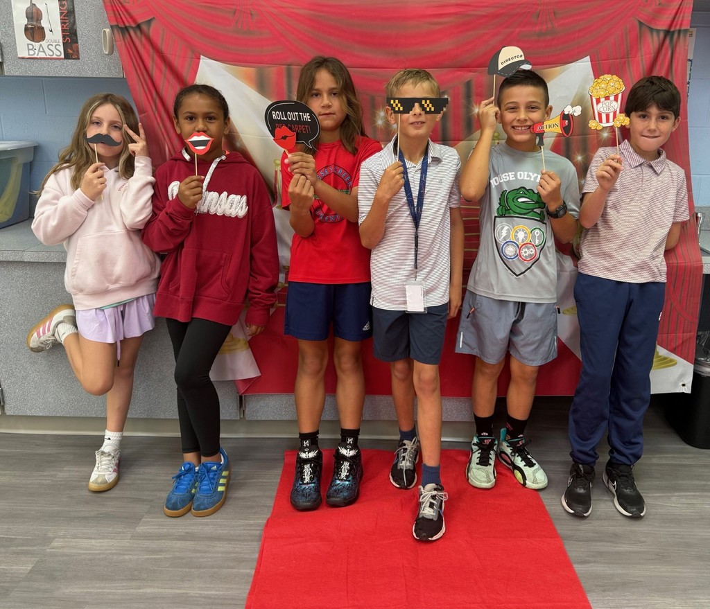 S.T.A.R. Gator Students pose in a room with a red carpet backdrop.