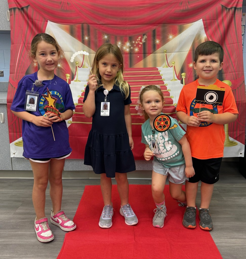S.T.A.R. Gator Students pose in a room with a red carpet backdrop.