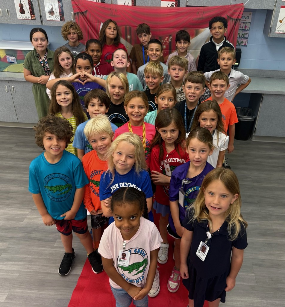 S.T.A.R. Gator Students pose in a room with a red carpet backdrop.
