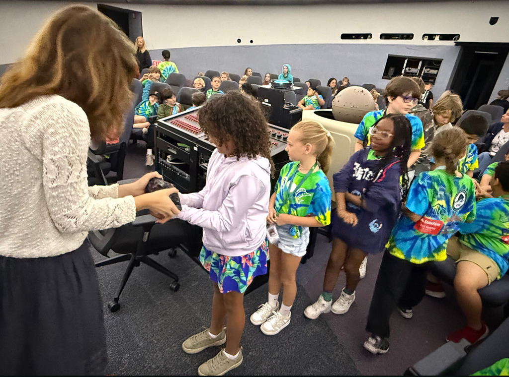 student holding meteorite 
