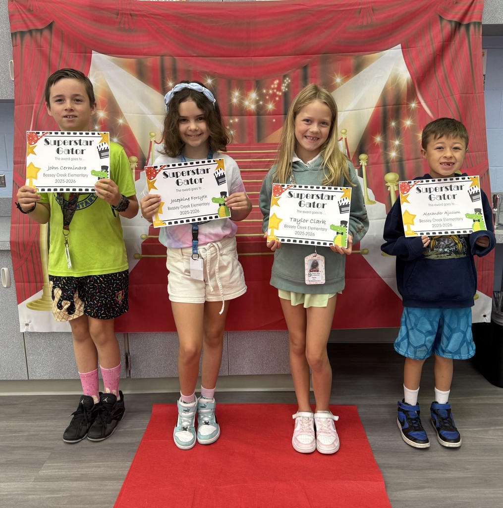 S.T.A.R. Gator Students pose in a room with a red carpet backdrop.
