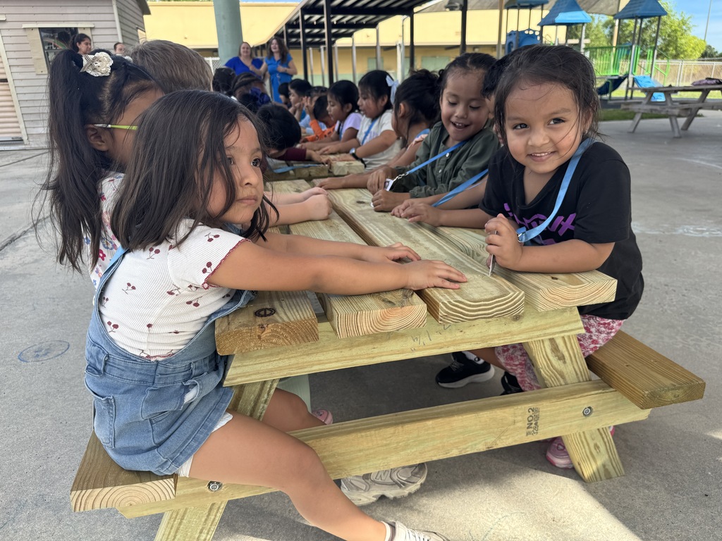 Port Salerno Learning center students smiling on new picnic bench made by SFHS construction students
