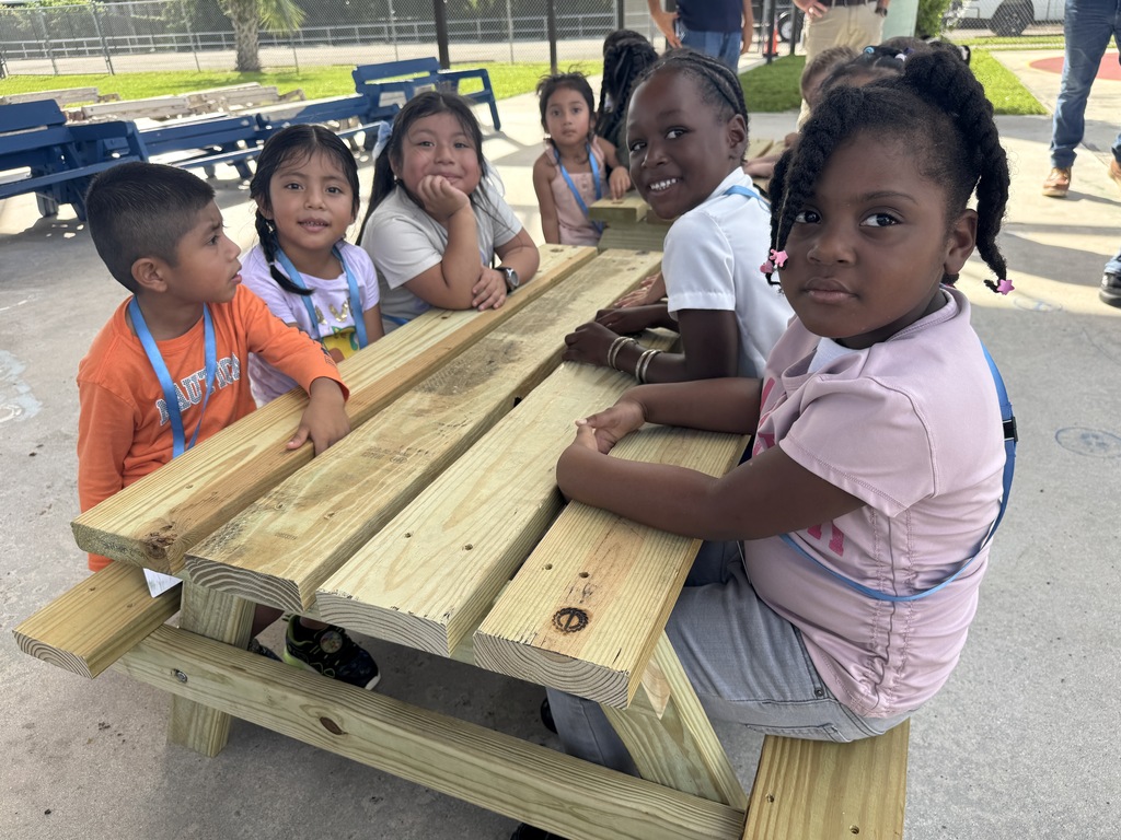 Port Salerno Learning center students smiling on new picnic bench made by SFHS construction students