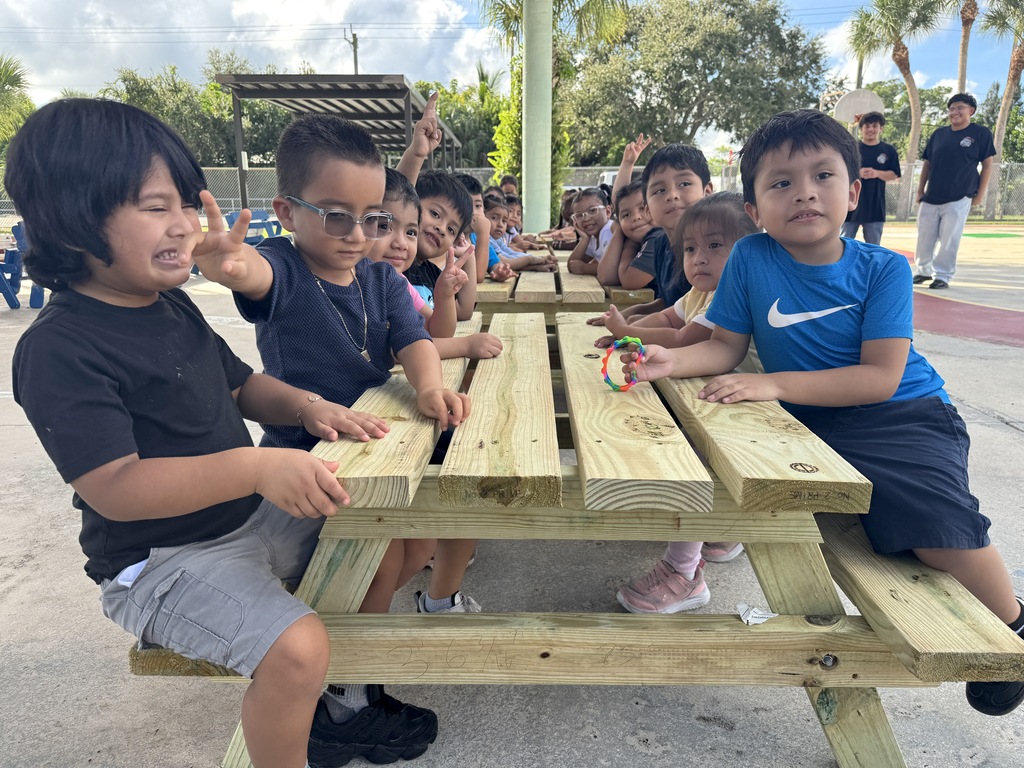 Port Salerno Learning center students smiling on new picnic bench made by SFHS construction students