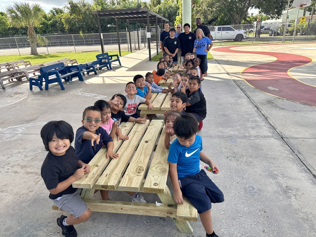 Port Salerno Learning center students smiling on new picnic bench made by SFHS construction students