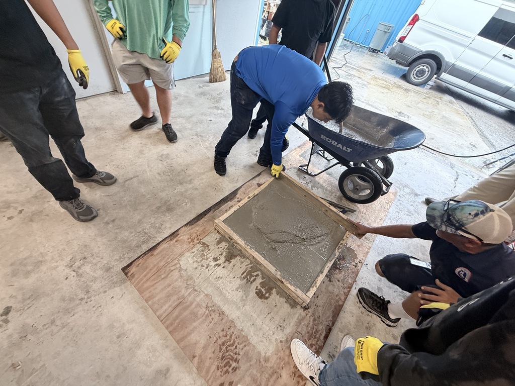 High school students learn how to pour concrete