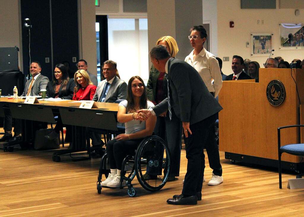 Elle Wall shakes and of Supt. Maine after being awarded Commissioner's Leadership Award during State Board of Education Meeting at Martin County School District