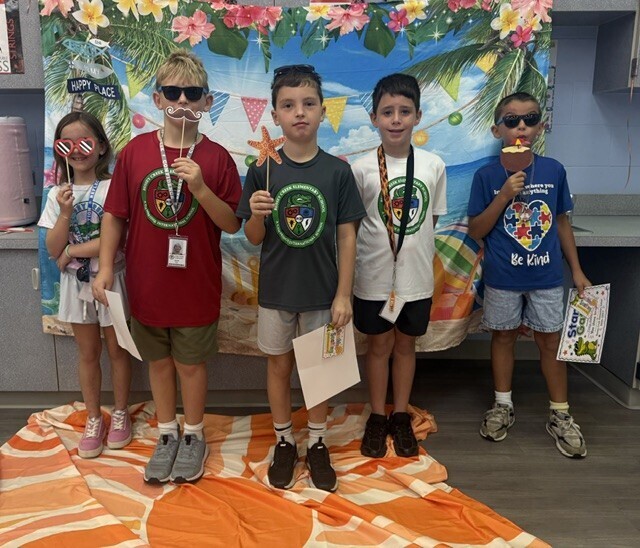 STAR Gator Students stand in front of a beach-themed backdrop.