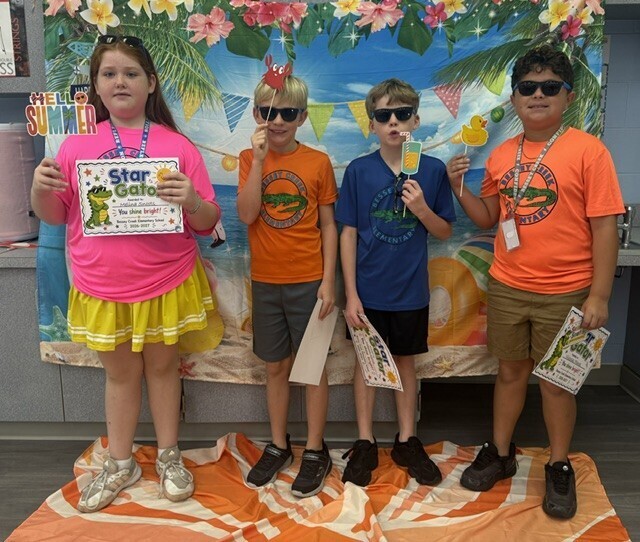 STAR Gator Students stand in front of a beach-themed backdrop.