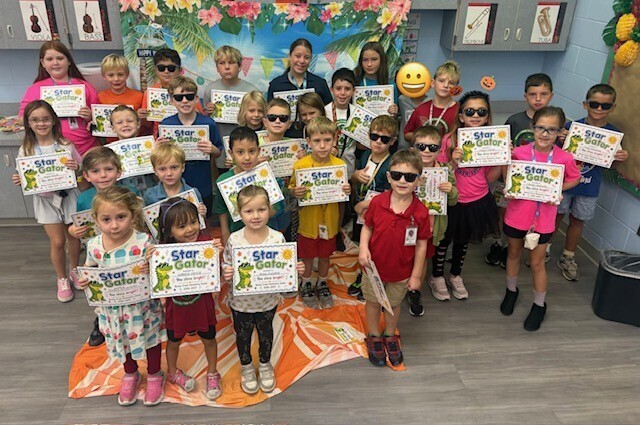 STAR Gator Students stand in front of a beach-themed backdrop.