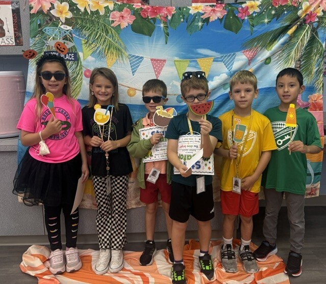 STAR Gator Students stand in front of a beach-themed backdrop.