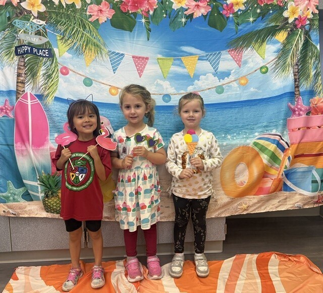 STAR Gator Students stand in front of a beach-themed backdrop.