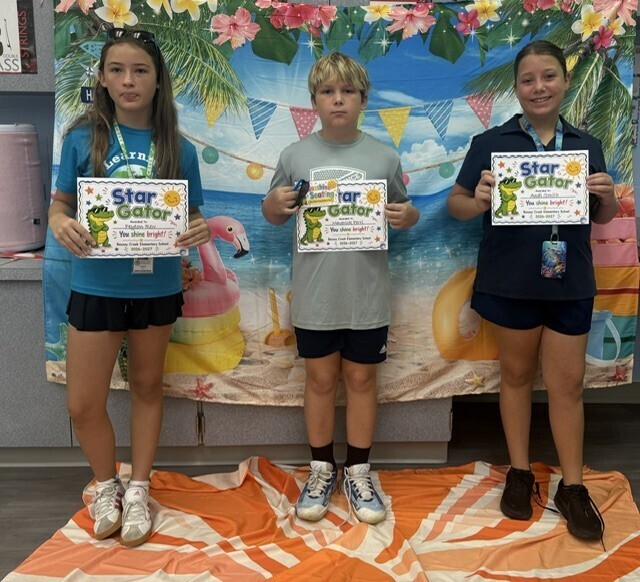 STAR Gator Students stand in front of a beach-themed backdrop.