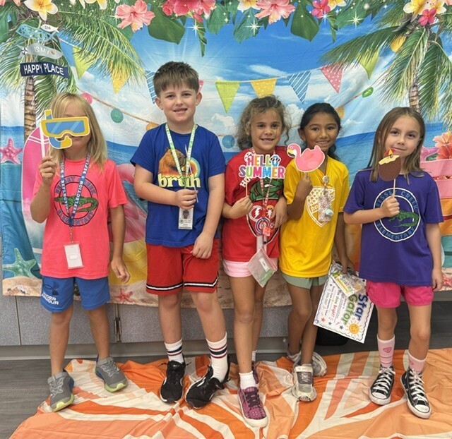 STAR Gators pose in front of a beach-themed backdrop.