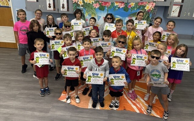 STAR Gators pose in front of a beach-themed backdrop.