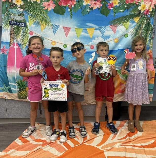 STAR Gators pose in front of a beach-themed backdrop.