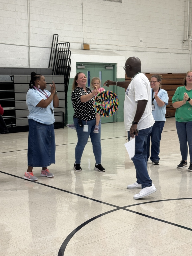 Mrs. Thompson is cheered on as she accepts her award from Principal Howard. 